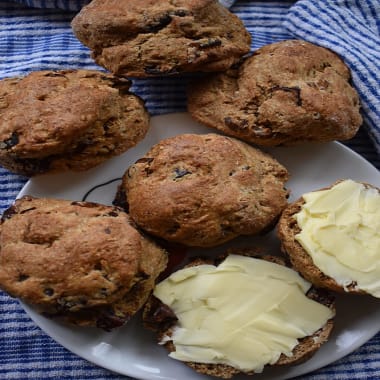 Date Scones laid out on a tea towel one cut in half spread with butter